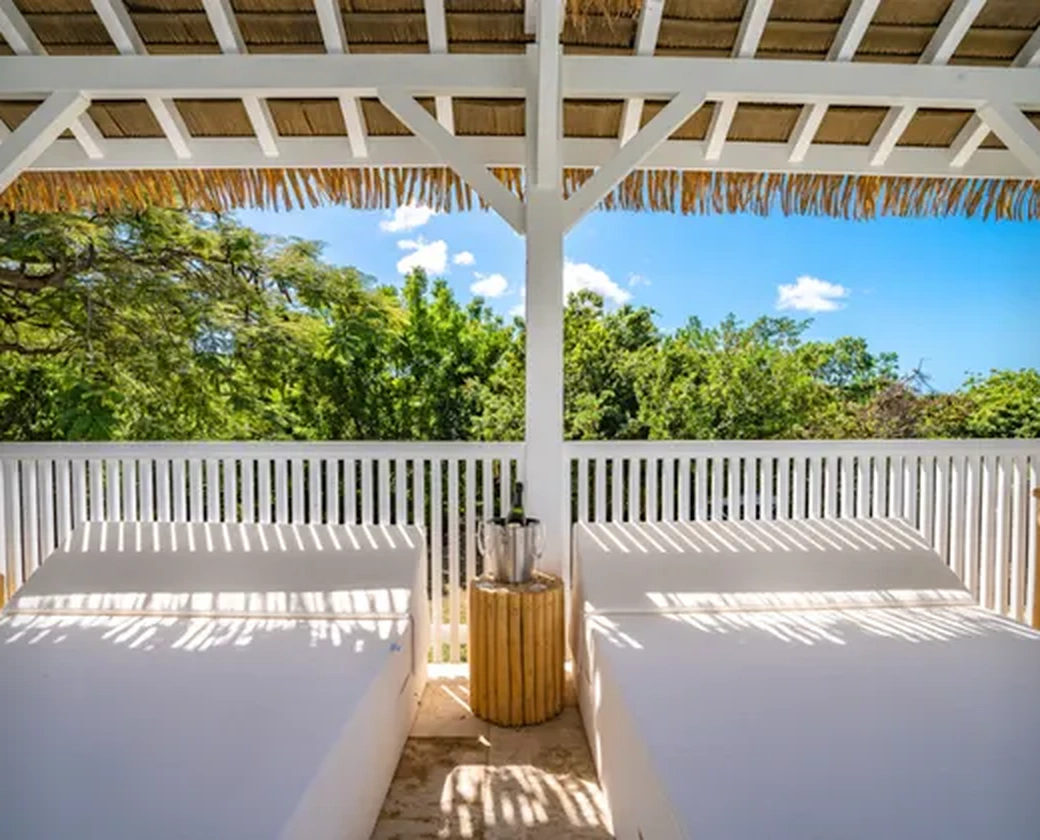 Daybeds in the shade of the thatched roof