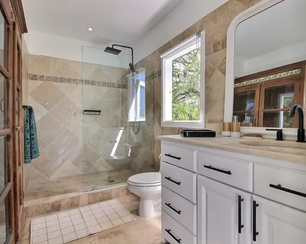 The bathroom with a glass shower and large mirror