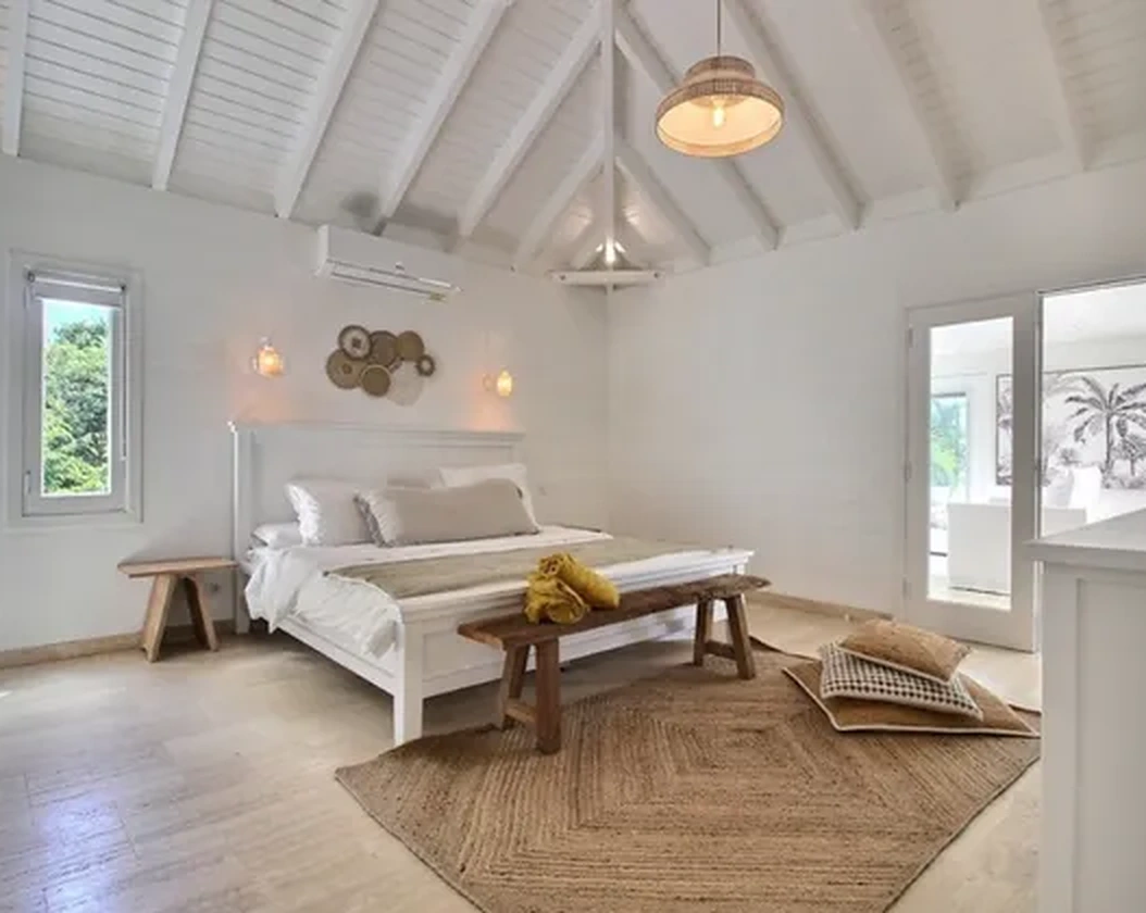 The bedroom beneath white roof beams
