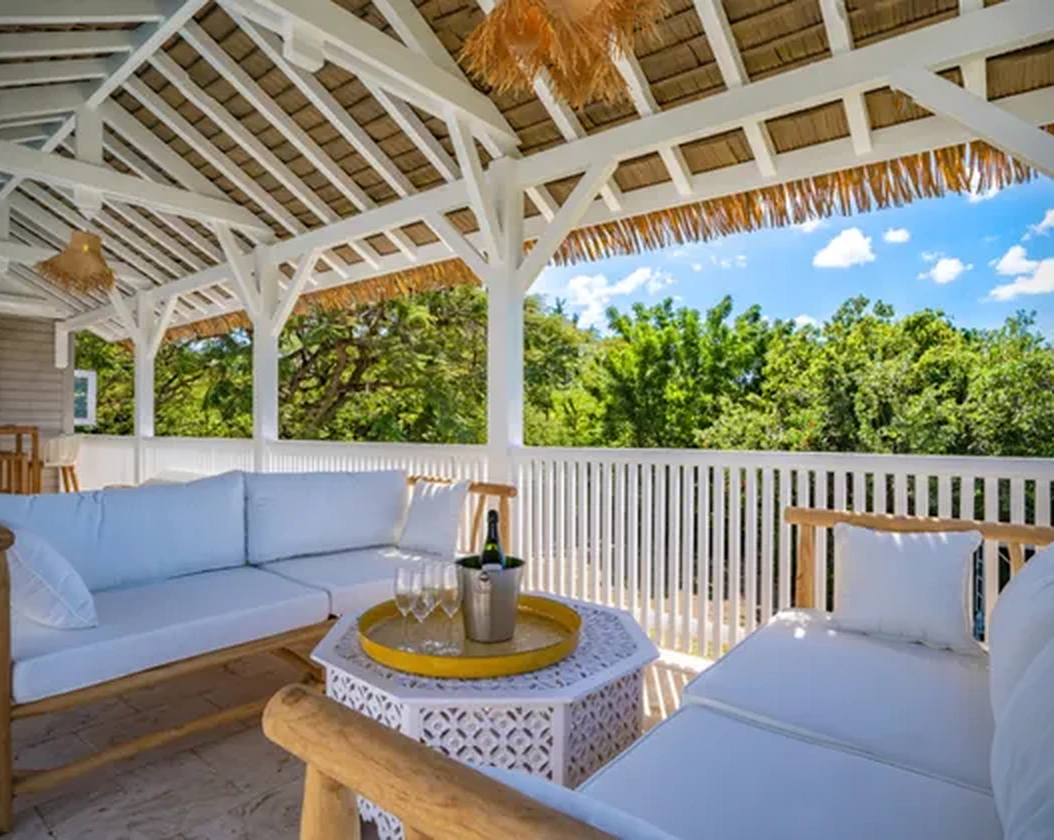 Terrace sofas beneath the palm-thatched roof
