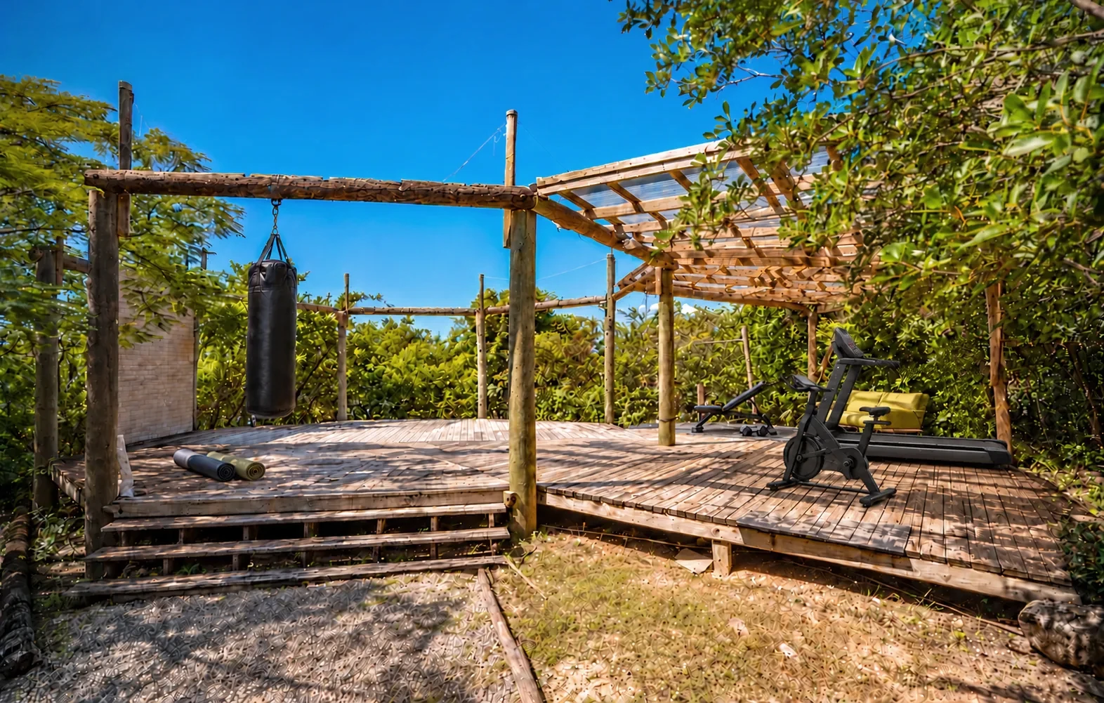 The wooden outdoor fitness platform and its equipment surrounded by greenery